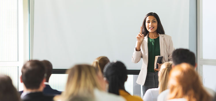 A female manager leads a  meeting for other employees.