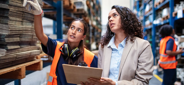 A manager talks to a worker in a warehouse