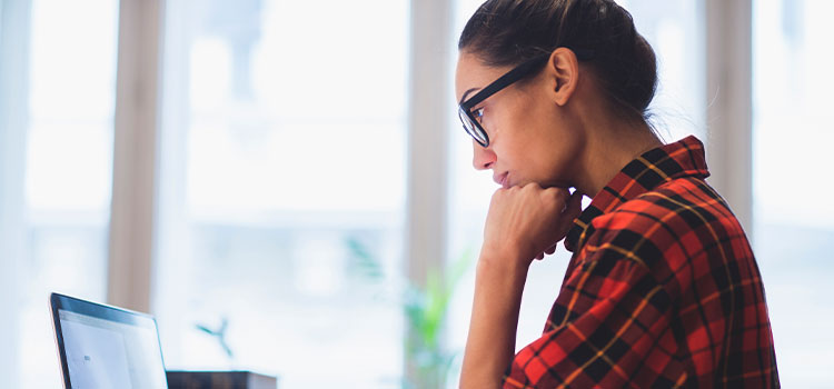 a woman reads information on her laptop