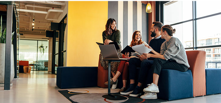 a group of students talk as they sit together in a campus building