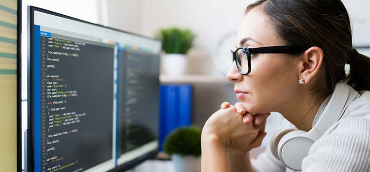woman intently looking at computer screen of data