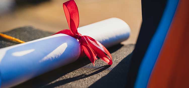 rolled paper diploma with red ribbon