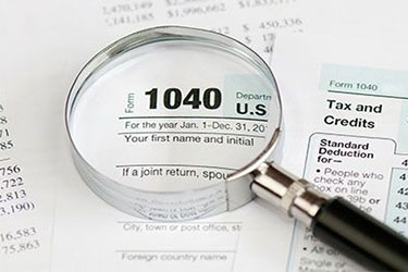 magnifying glass inspecting irs 1040