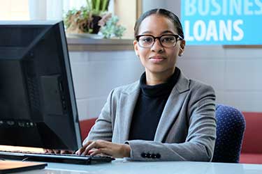 female loan officer sits at computer